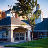 Outside view of the front entrance way at Blakehurst with a covered porch-like structure for vehicles to drive through, which has a weather vane on top.