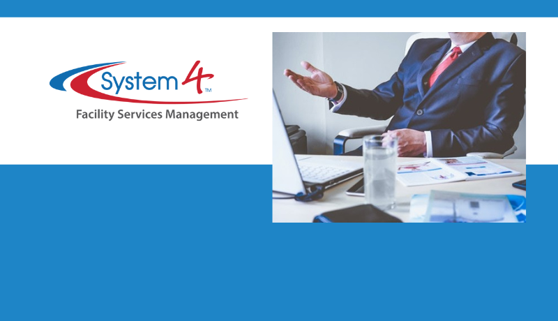 Systems 4 Logo with image of man in blue suit and red tie sitting at a desk with lap top and documents spread out on the table. There is a large glass of what appears to be water on the table.